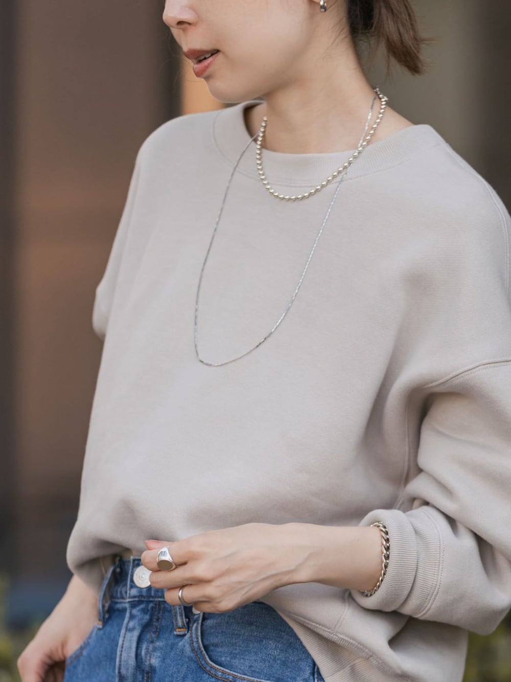 ベージュ系のスウェット、ブルー系のデニムスカートを着用したレディースの秋コーディネートの4枚目の写真