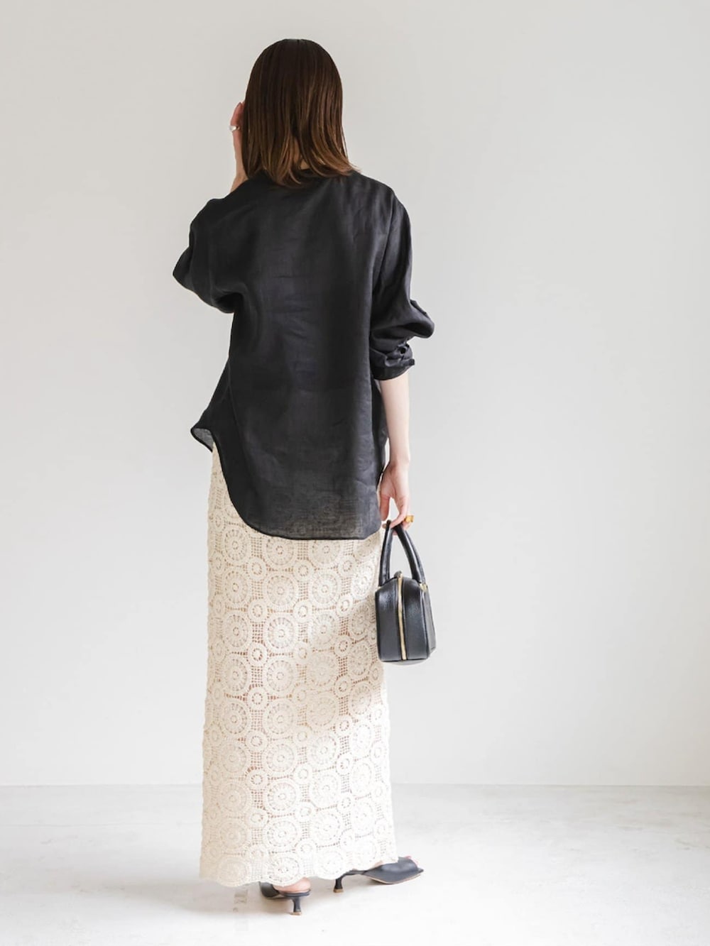 ブラック系のシャツ/ブラウス、ホワイト系のスカート、ブラック系のショルダーバッグを着用したレディースの夏コーディネートの2枚目の写真