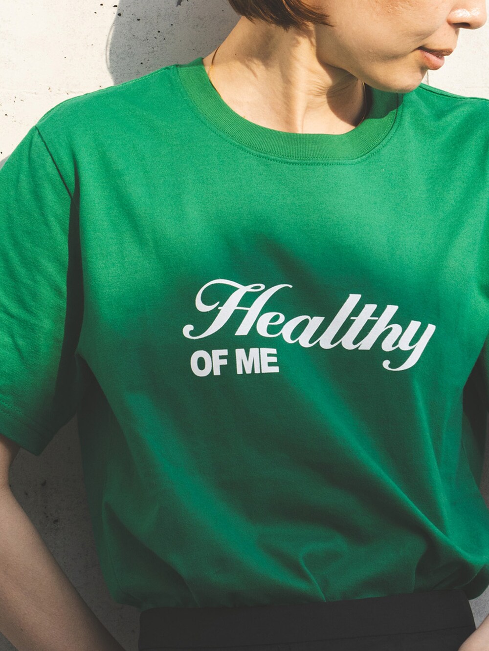 グリーン系のTシャツ/カットソー、ブラック系のスカートを着用したレディースの夏コーディネートの3枚目の写真