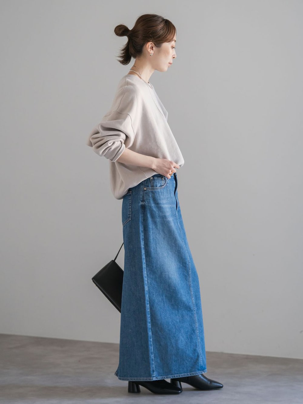 ベージュ系のスウェット、ブルー系のデニムスカートを着用したレディースの秋コーディネートの2枚目の写真