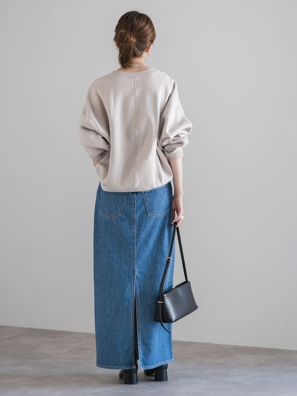 ベージュ系のスウェット、ブルー系のデニムスカートを着用したレディースの秋コーディネートの3枚目の写真