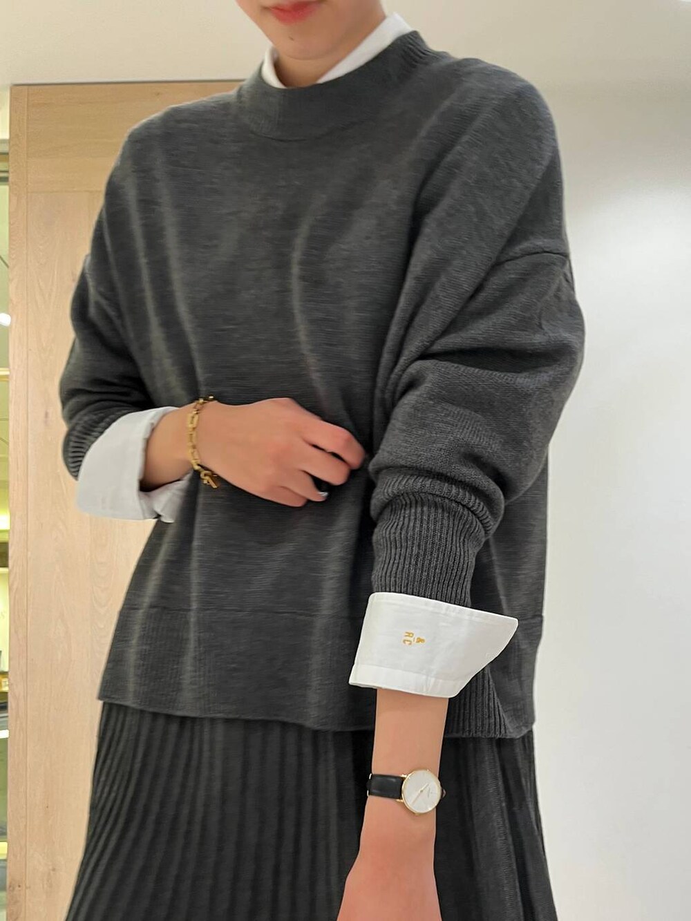 グレー系のワンピース、ホワイト系のシャツ/ブラウス、ブラック系のショルダーバッグを着用したレディースの冬コーディネートの4枚目の写真