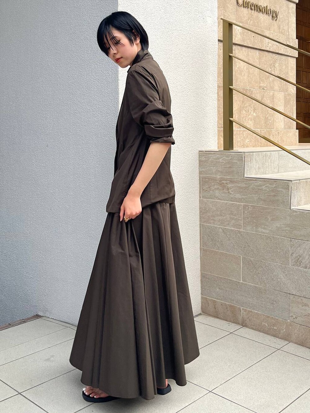 ブラック系のサンダル、グリーン系のスカート、グリーン系のテーラードジャケットを着用したレディースの夏コーディネートの4枚目の写真