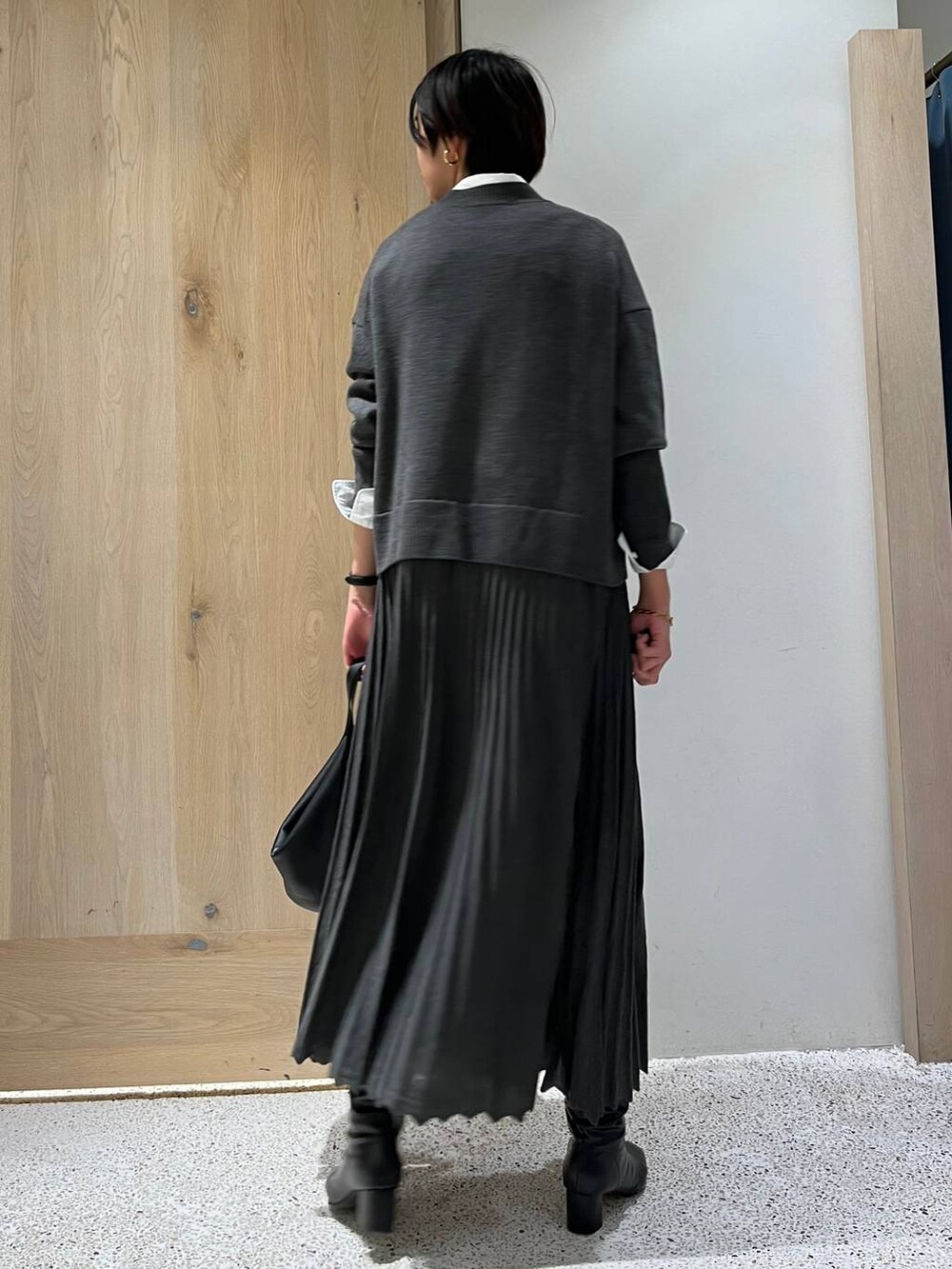 グレー系のワンピース、ホワイト系のシャツ/ブラウス、ブラック系のショルダーバッグを着用したレディースの冬コーディネートの3枚目の写真