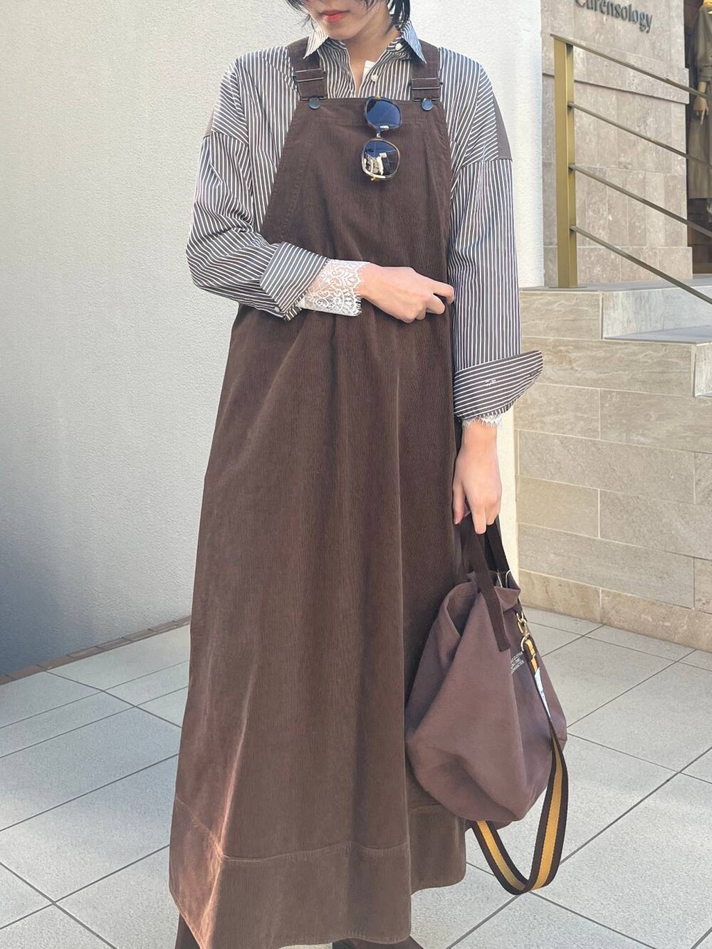 ブラウン系のジャンパースカート、ブラウン系のトートバッグ、ブラウン系のシャツ/ブラウスを着用したレディースの冬コーディネートの4枚目の写真