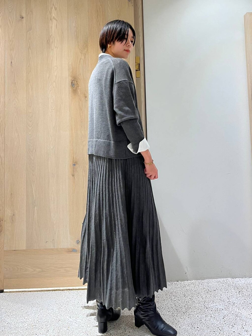 グレー系のワンピース、ホワイト系のシャツ/ブラウス、ブラック系のショルダーバッグを着用したレディースの冬コーディネートの2枚目の写真