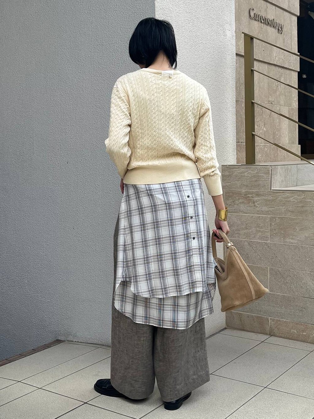 ベージュ系のその他パンツ、ホワイト系のシャツ/ブラウス、ゴールド系のバングル/リストバンドを着用したレディースの冬コーディネートの3枚目の写真