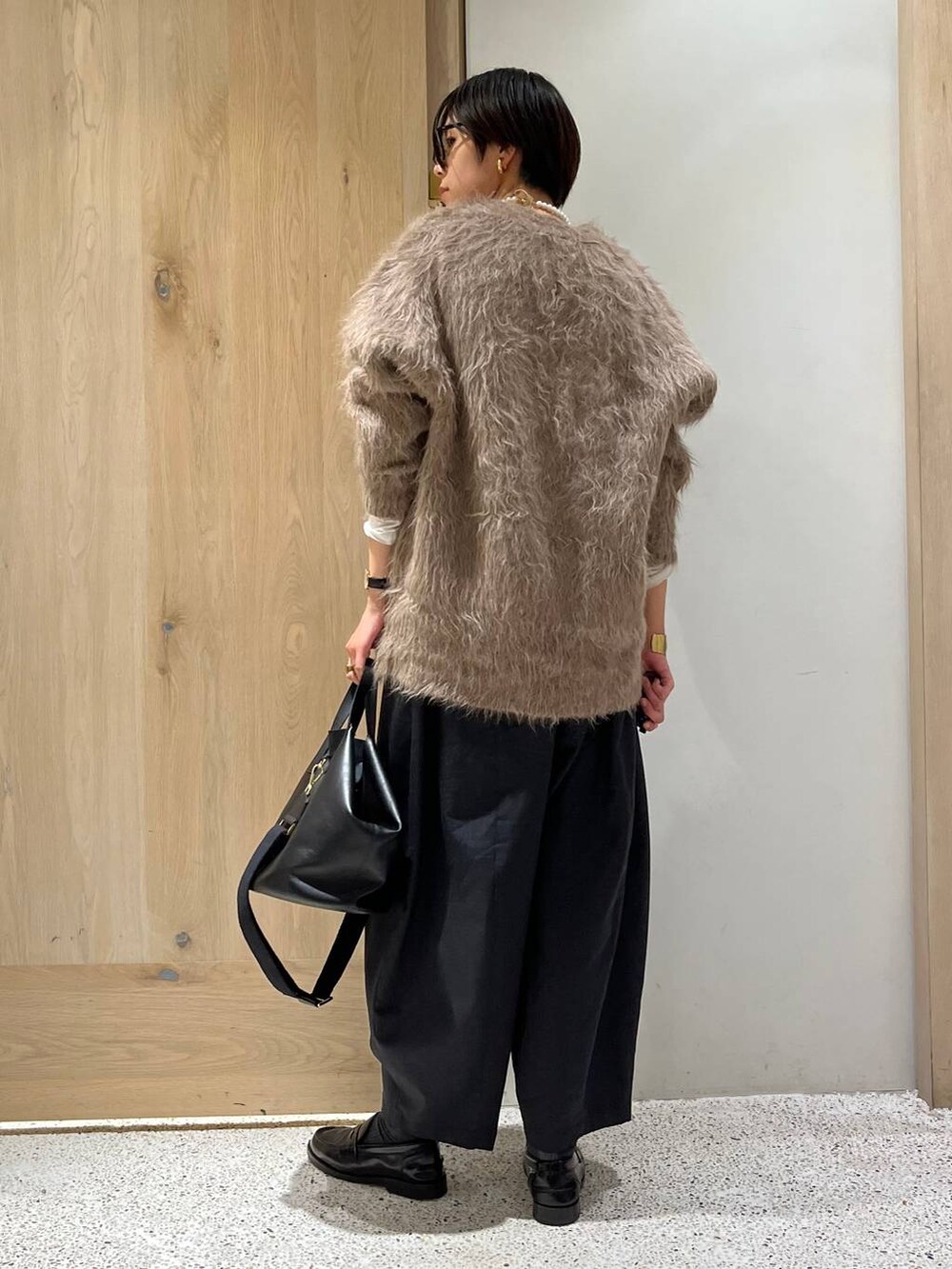 ベージュ系のカーディガン/ボレロ、グレー系のその他パンツ、ブラック系のショルダーバッグを着用したレディースの冬コーディネートの3枚目の写真