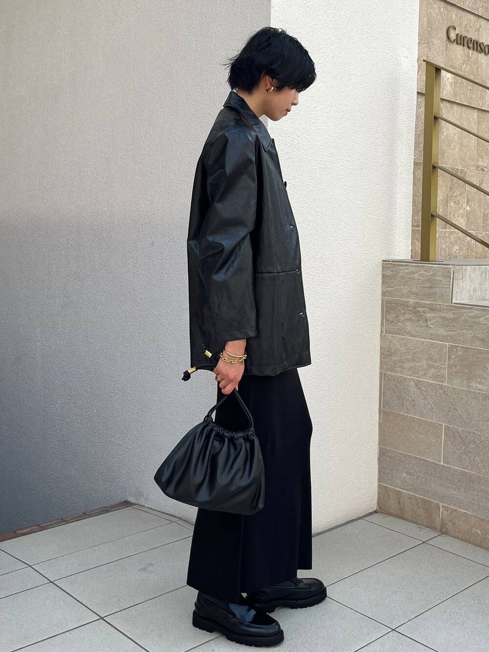 ホワイト系のシャツ/ブラウス、ブラック系のブルゾン、ブラック系のスカートを着用したレディースの秋コーディネートの2枚目の写真