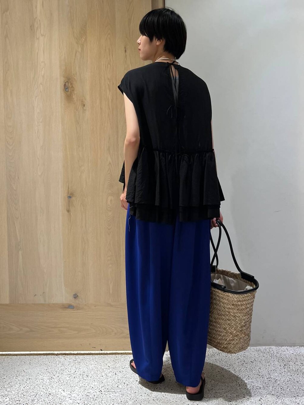 ブラック系のサンダル、ブルー系のその他パンツ、ブラック系のハンドバッグを着用したレディースの夏コーディネートの3枚目の写真