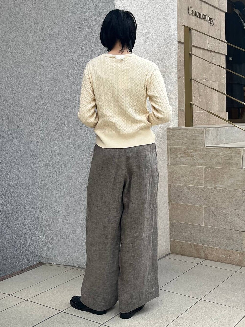 ベージュ系のその他パンツ、ホワイト系のシャツ/ブラウス、ゴールド系のバングル/リストバンドを着用したレディースの冬コーディネートの6枚目の写真