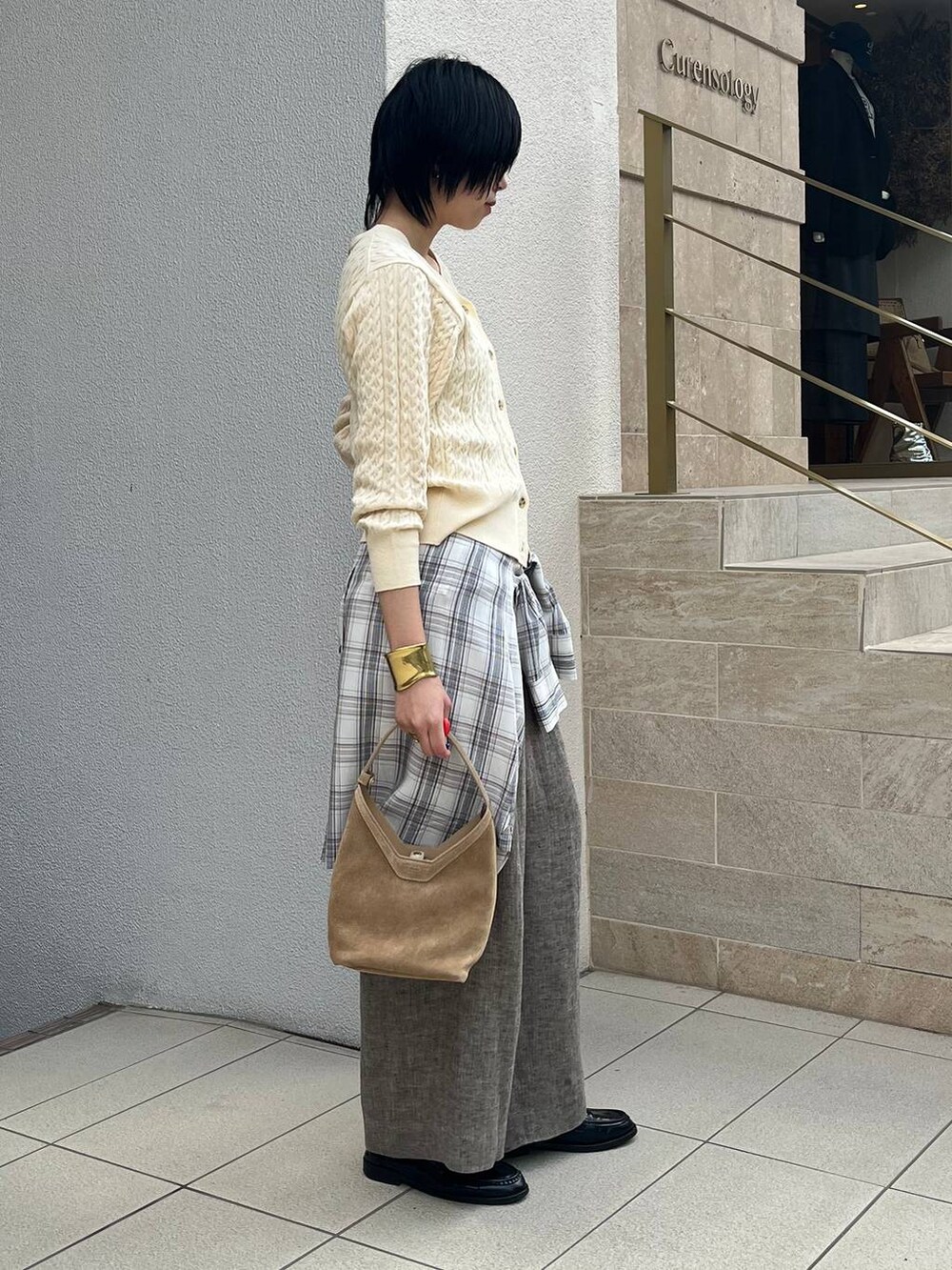 ベージュ系のその他パンツ、ホワイト系のシャツ/ブラウス、ゴールド系のバングル/リストバンドを着用したレディースの冬コーディネートの2枚目の写真