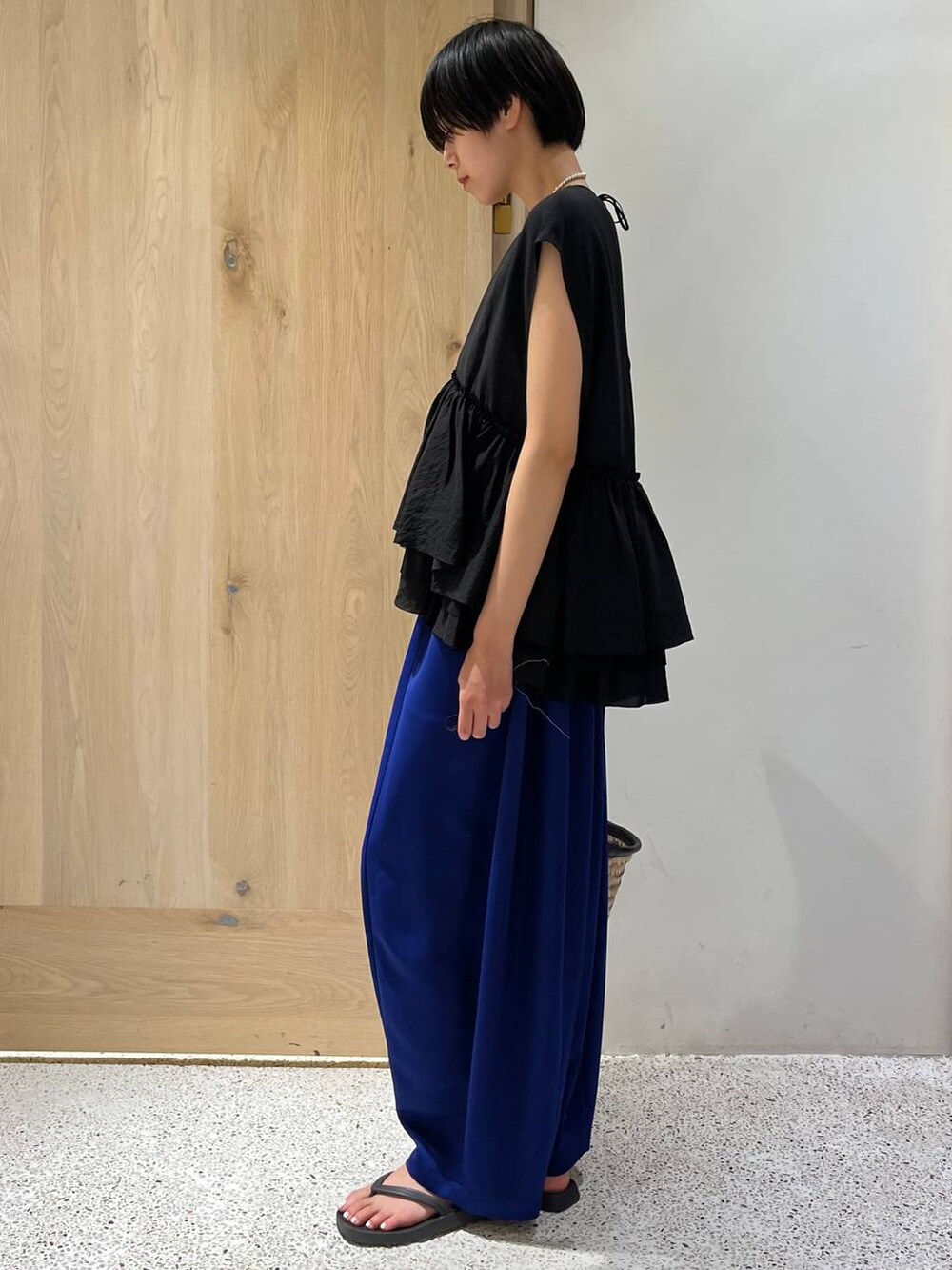 ブラック系のサンダル、ブルー系のその他パンツ、ブラック系のハンドバッグを着用したレディースの夏コーディネートの2枚目の写真