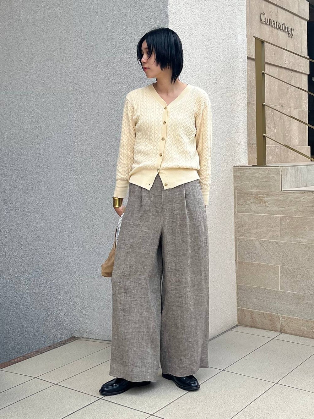 ベージュ系のその他パンツ、ホワイト系のシャツ/ブラウス、ゴールド系のバングル/リストバンドを着用したレディースの冬コーディネートの4枚目の写真