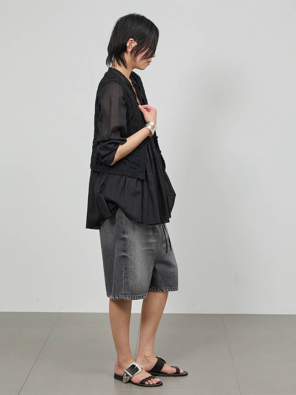 ブラック系のデニムパンツ、ブラック系のベストを着用したレディースの冬コーディネートの3枚目の写真