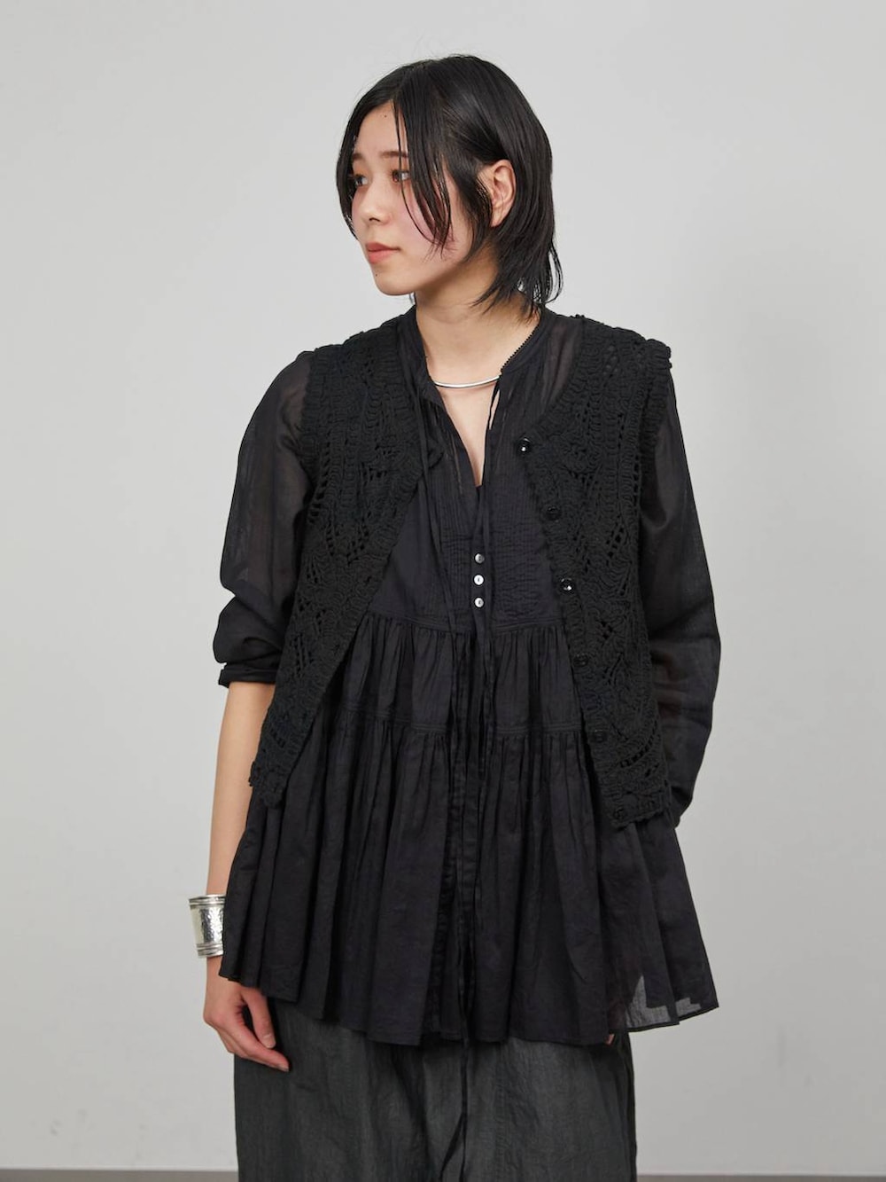 ブラック系のデニムパンツ、ブラック系のベストを着用したレディースの冬コーディネートの5枚目の写真