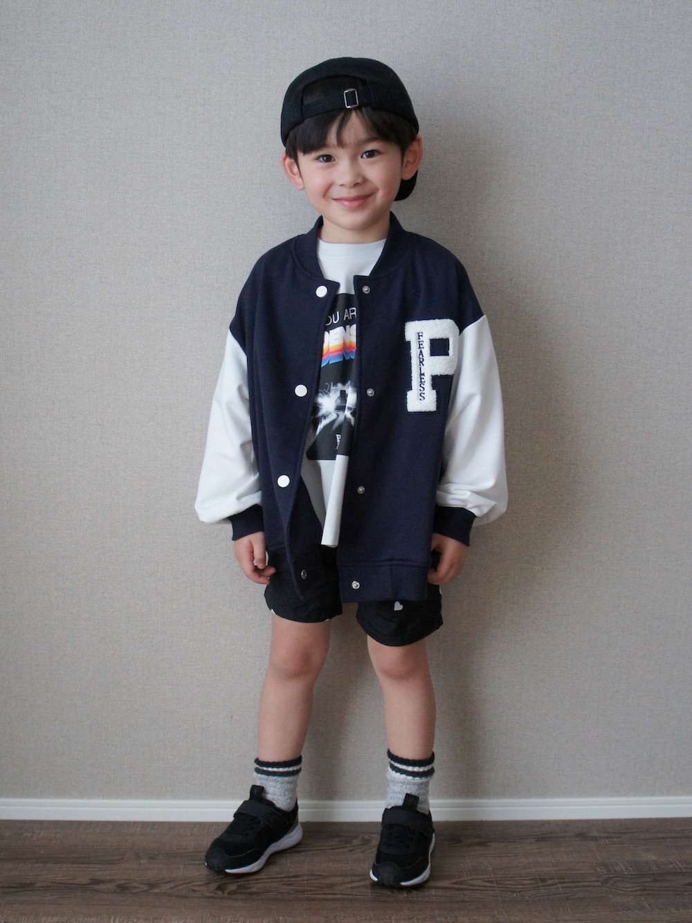 ブルー系のスタジャン、グレー系のTシャツ/カットソー、ブラック系のその他パンツを着用したキッズの春コーディネートの3枚目の写真