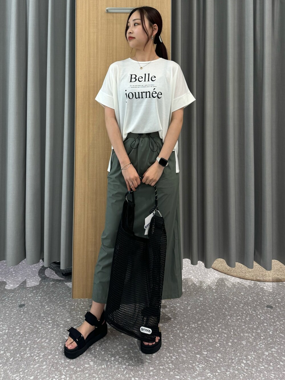 グリーン系のスカート、ホワイト系のブルゾン、ホワイト系のTシャツ/カットソーを着用したレディースの夏コーディネートの5枚目の写真