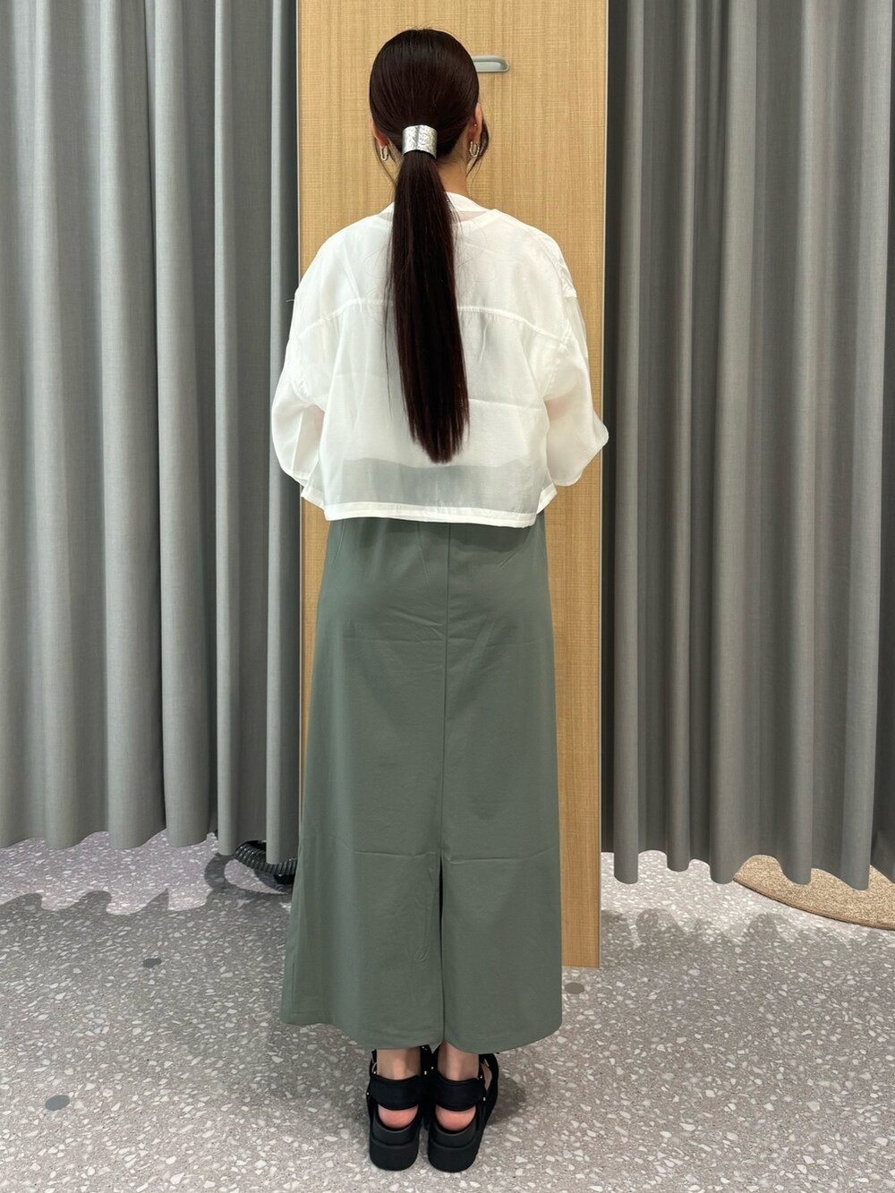 グリーン系のスカート、ホワイト系のブルゾン、ホワイト系のTシャツ/カットソーを着用したレディースの夏コーディネートの4枚目の写真