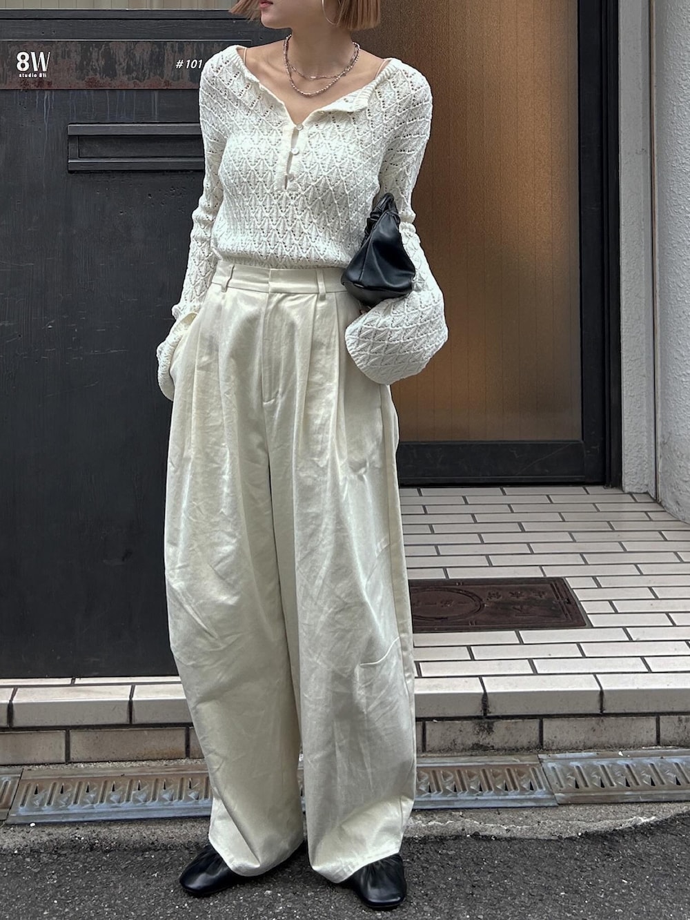 ホワイト系のニット/セーター、ホワイト系のチノパンツ、ブラック系のバレエシューズを着用したレディースの冬コーディネートの3枚目の写真