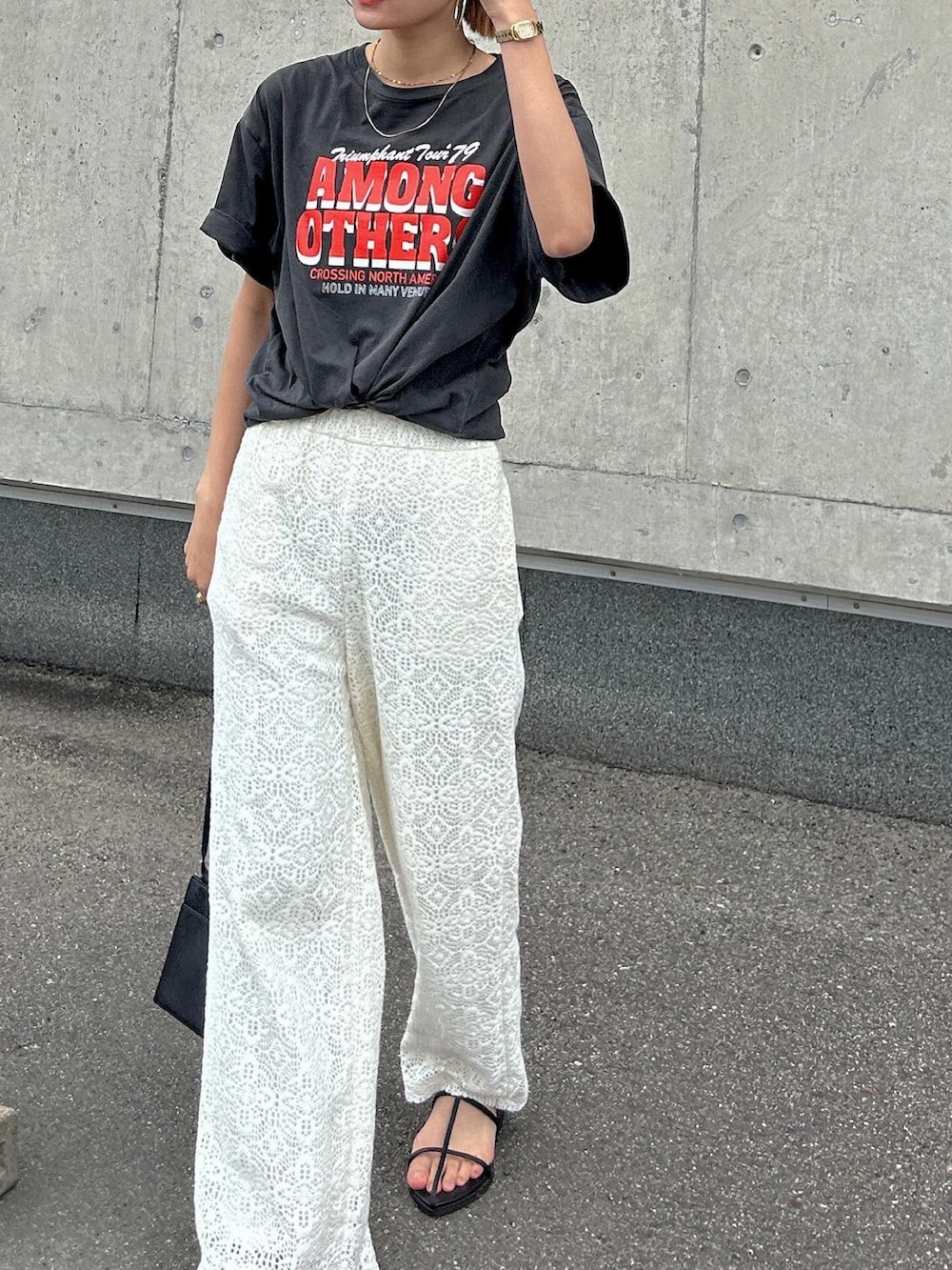 オレンジ系のTシャツ/カットソー、ブラック系のボディバッグ/ウエストポーチ、ブラック系のサンダルを着用したレディースの春コーディネートの3枚目の写真