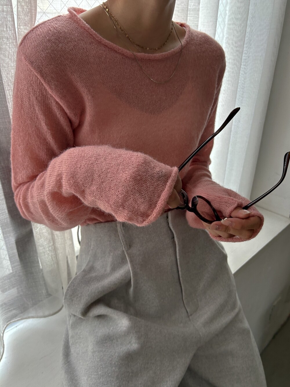 ピンク系のニット/セーター、グレー系のその他パンツ、ホワイト系のハンドバッグを着用したレディースの秋コーディネートの4枚目の写真