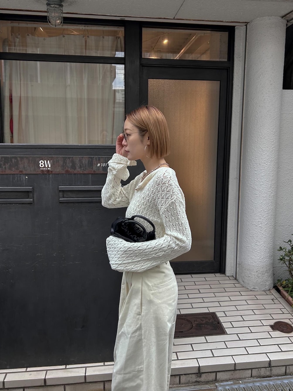 ホワイト系のニット/セーター、ホワイト系のチノパンツ、ブラック系のバレエシューズを着用したレディースの冬コーディネートの4枚目の写真