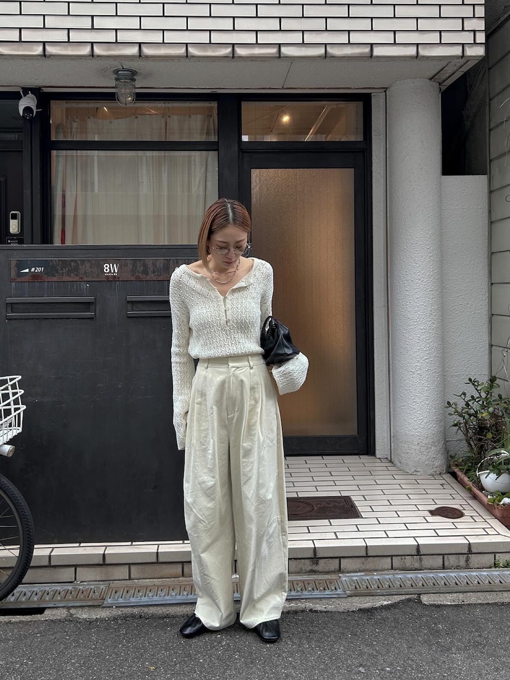 ホワイト系のニット/セーター、ホワイト系のチノパンツ、ブラック系のバレエシューズを着用したレディースの冬コーディネートの2枚目の写真