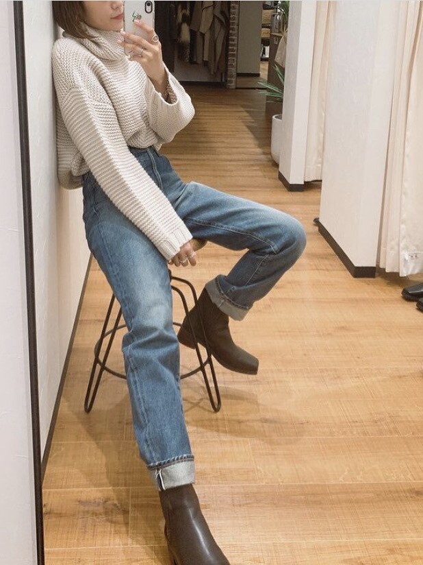 ブラウン系のブーツ、ブルー系のデニムパンツを着用したレディースの冬コーディネートの2枚目の写真