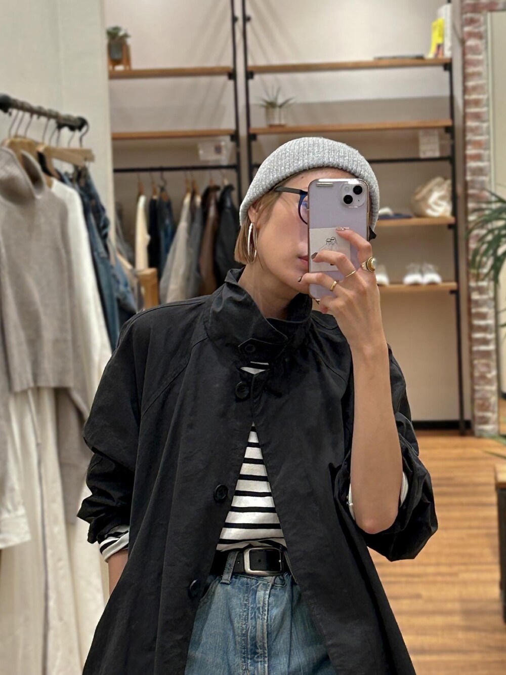 ブルー系のTシャツ/カットソー、ブルー系のデニムパンツ、ブラック系のステンカラーコートを着用したレディースの秋コーディネートの2枚目の写真