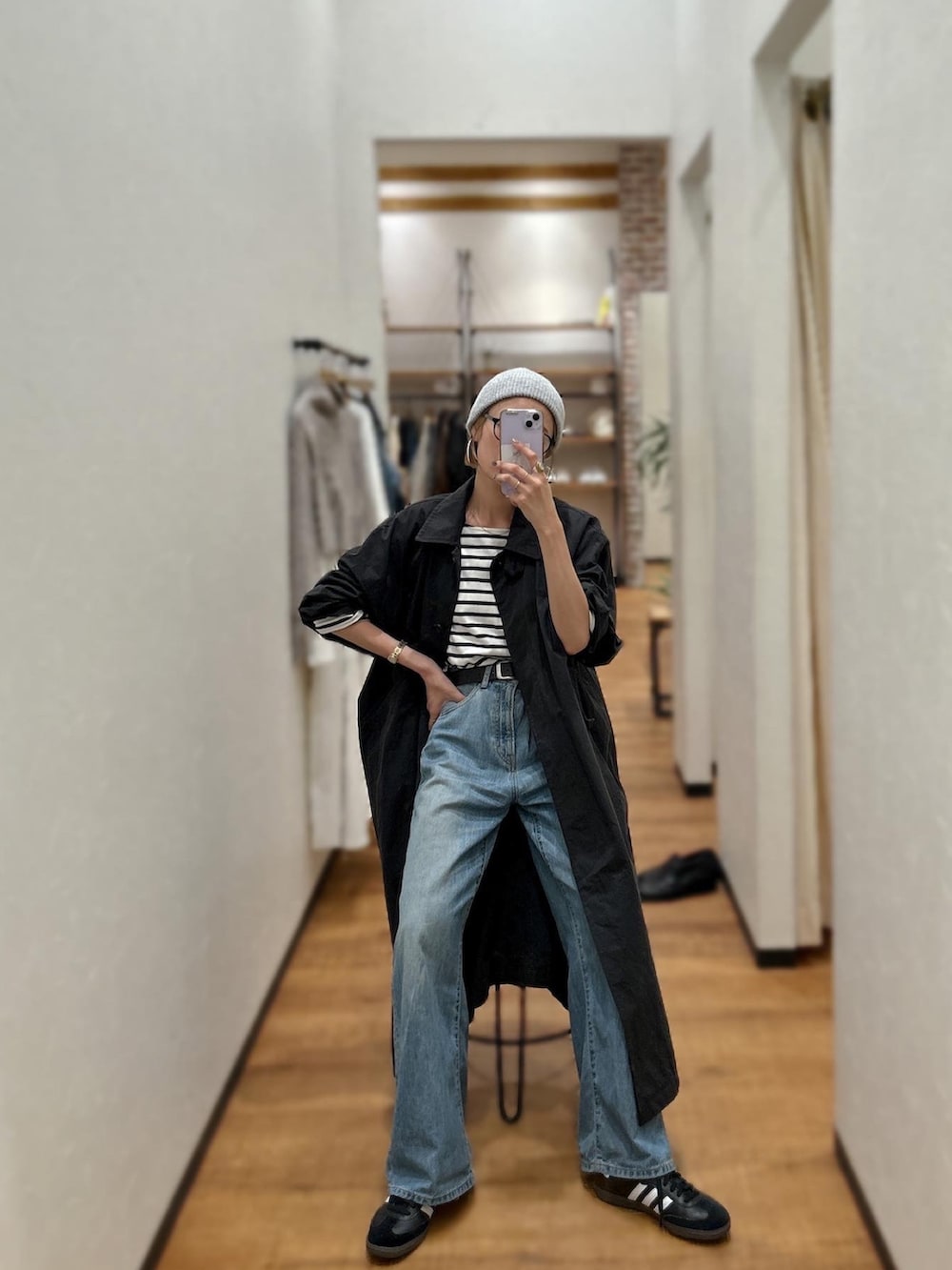 ブルー系のTシャツ/カットソー、ブルー系のデニムパンツ、ブラック系のステンカラーコートを着用したレディースの秋コーディネートの3枚目の写真