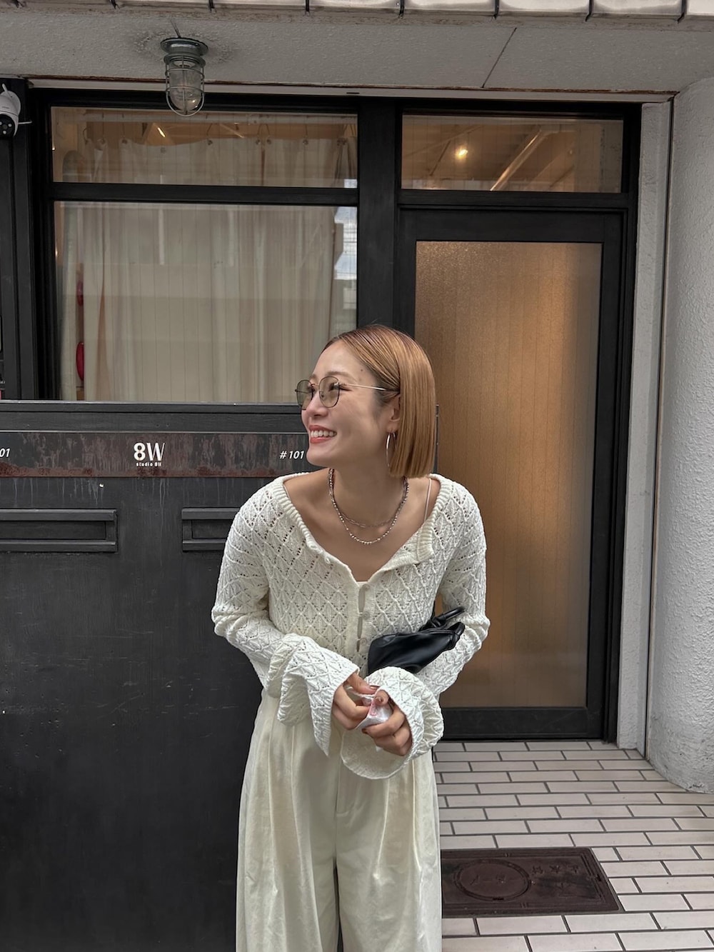 ホワイト系のニット/セーター、ホワイト系のチノパンツ、ブラック系のバレエシューズを着用したレディースの冬コーディネートの5枚目の写真