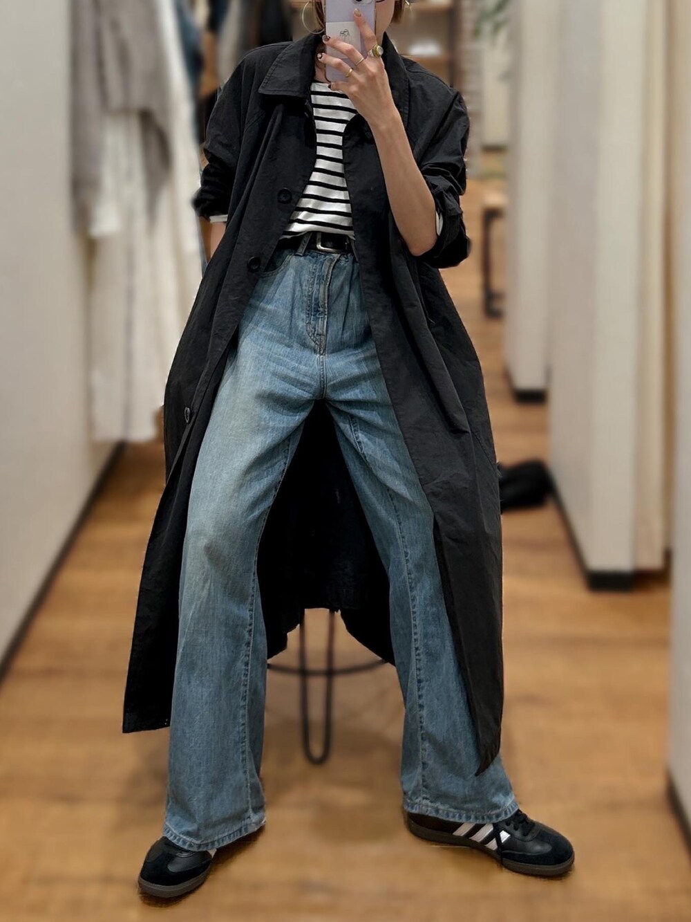 ブルー系のTシャツ/カットソー、ブルー系のデニムパンツ、ブラック系のステンカラーコートを着用したレディースの秋コーディネートの4枚目の写真