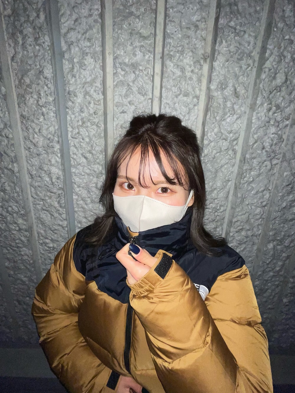 ブラウン系のダウンジャケット/コート、ブラック系のブーツを着用したレディースの冬コーディネートの2枚目の写真