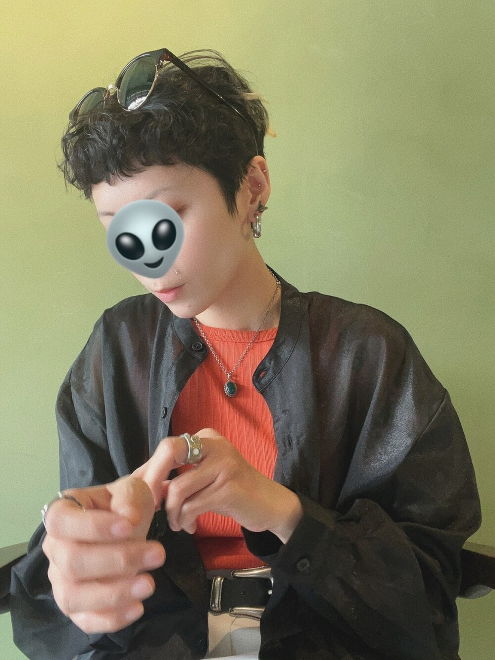 オレンジ系のトップス、シルバー系のアクセサリー、ブラック系の腕時計を着用したレディースの冬コーディネートの2枚目の写真