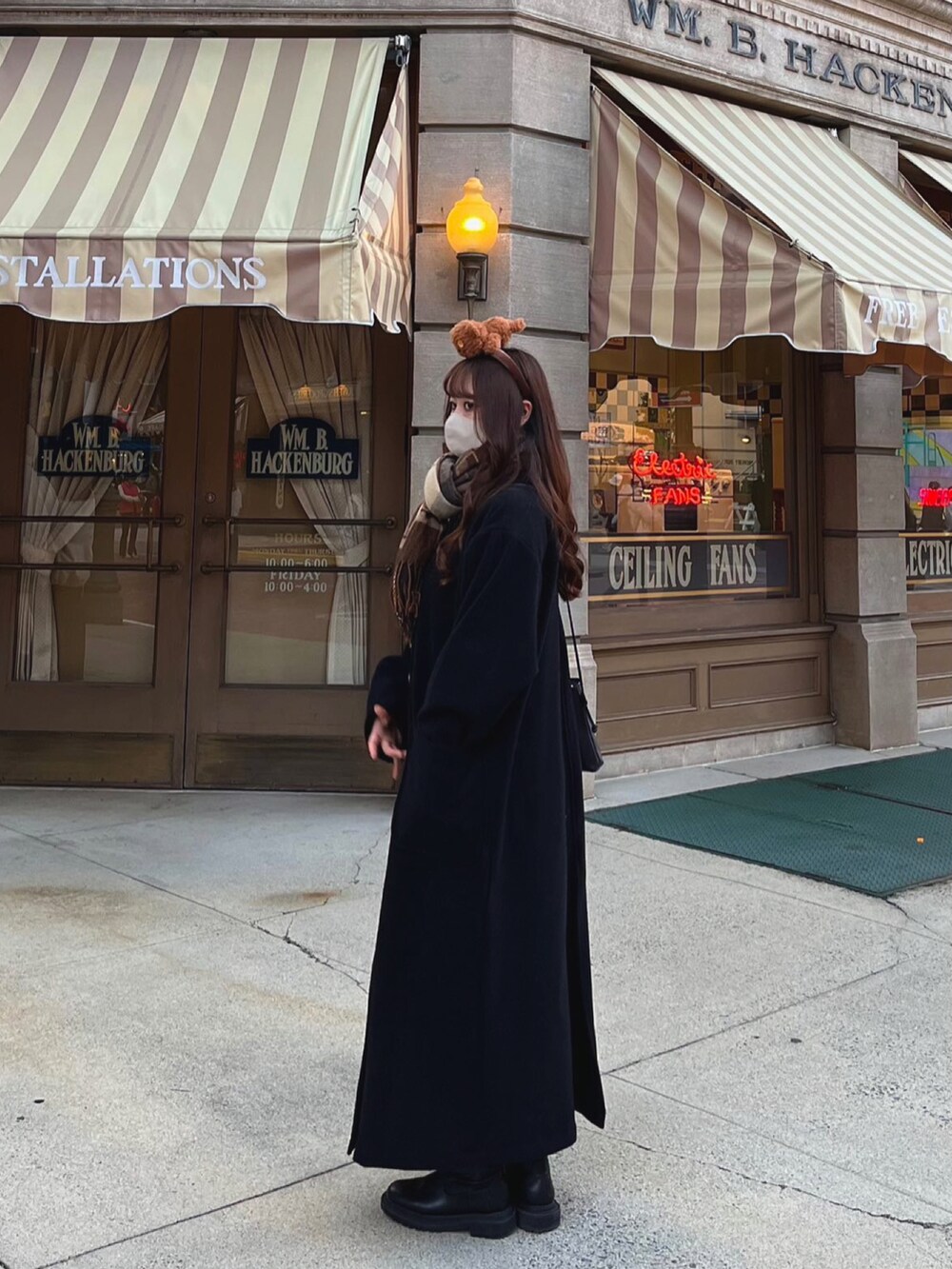 ブラック系のブーツ、ブラック系のノーカラーコートを着用したレディースの冬コーディネートの2枚目の写真