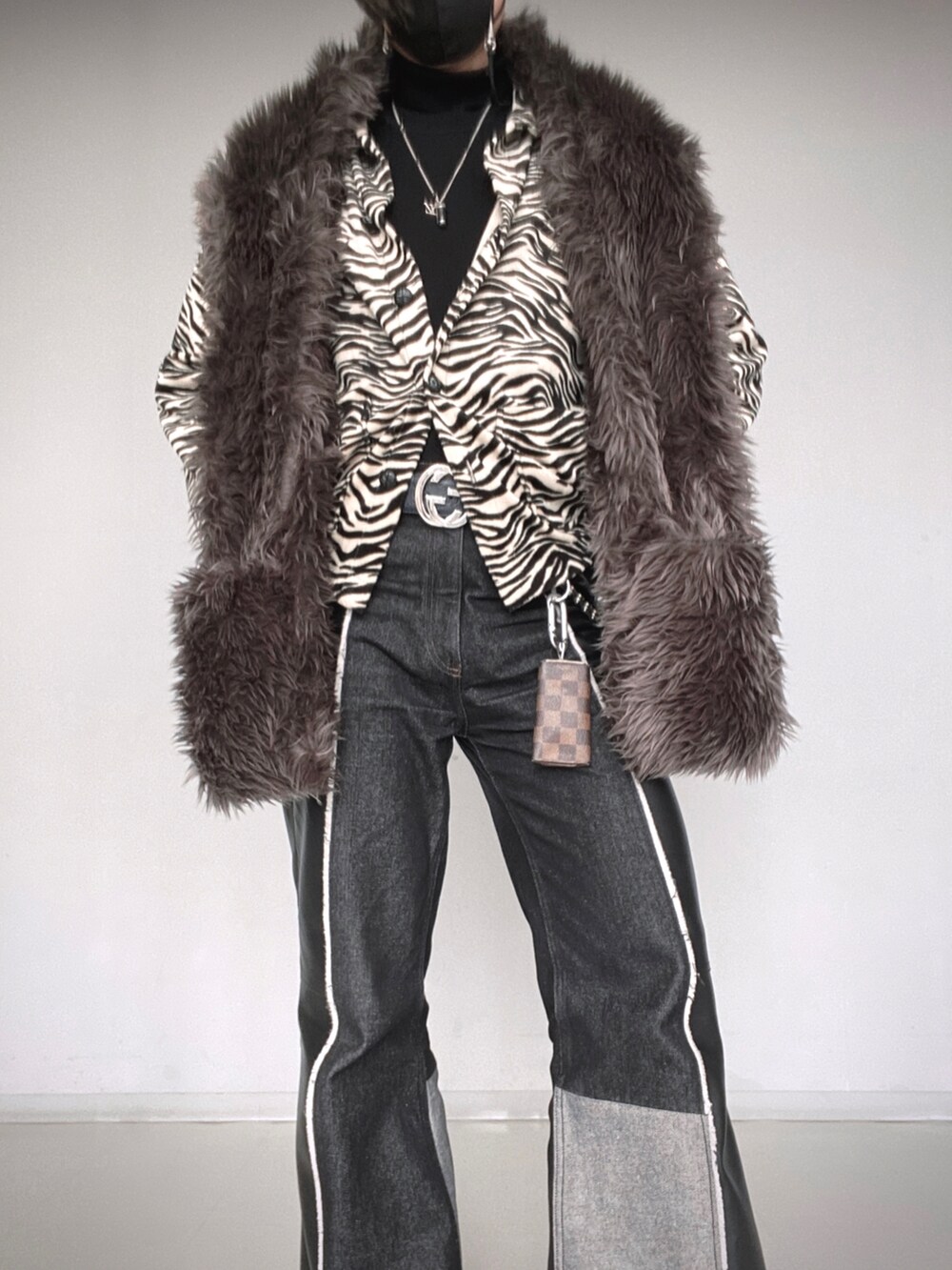 ブラック系のパンツ、ブラック系のシューズ、グレー系のマフラーを着用したメンズの冬コーディネートの5枚目の写真