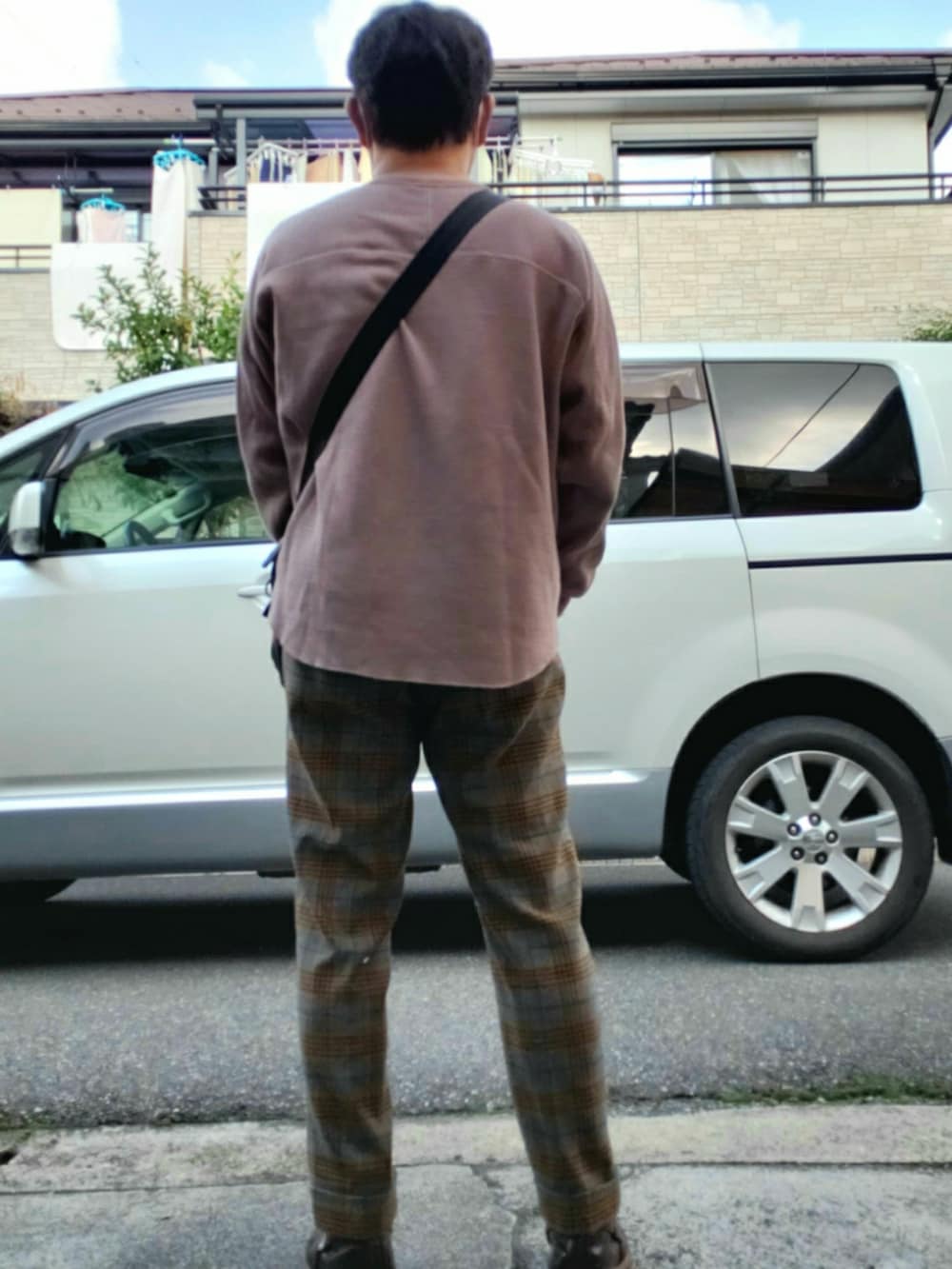 ブラウン系のスウェット、ブラック系のショルダーバッグ、ブラウン系のパンツを着用したメンズの秋コーディネートの2枚目の写真