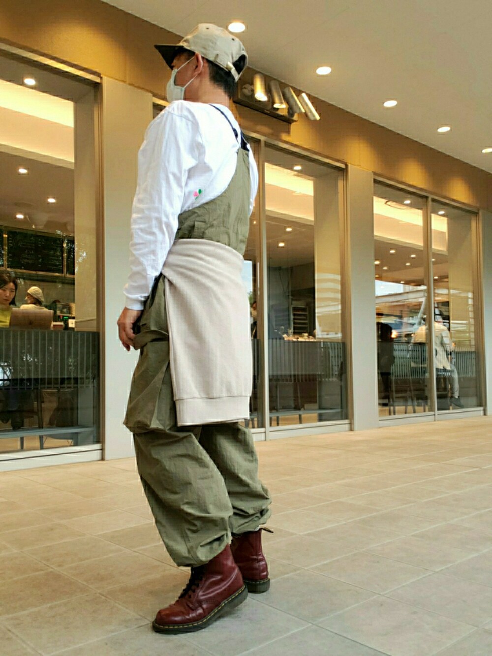 グリーン系のサロペット/オーバーオール、ブラウン系のブーツ、ホワイト系のTシャツ/カットソーを着用したメンズの春コーディネートの2枚目の写真