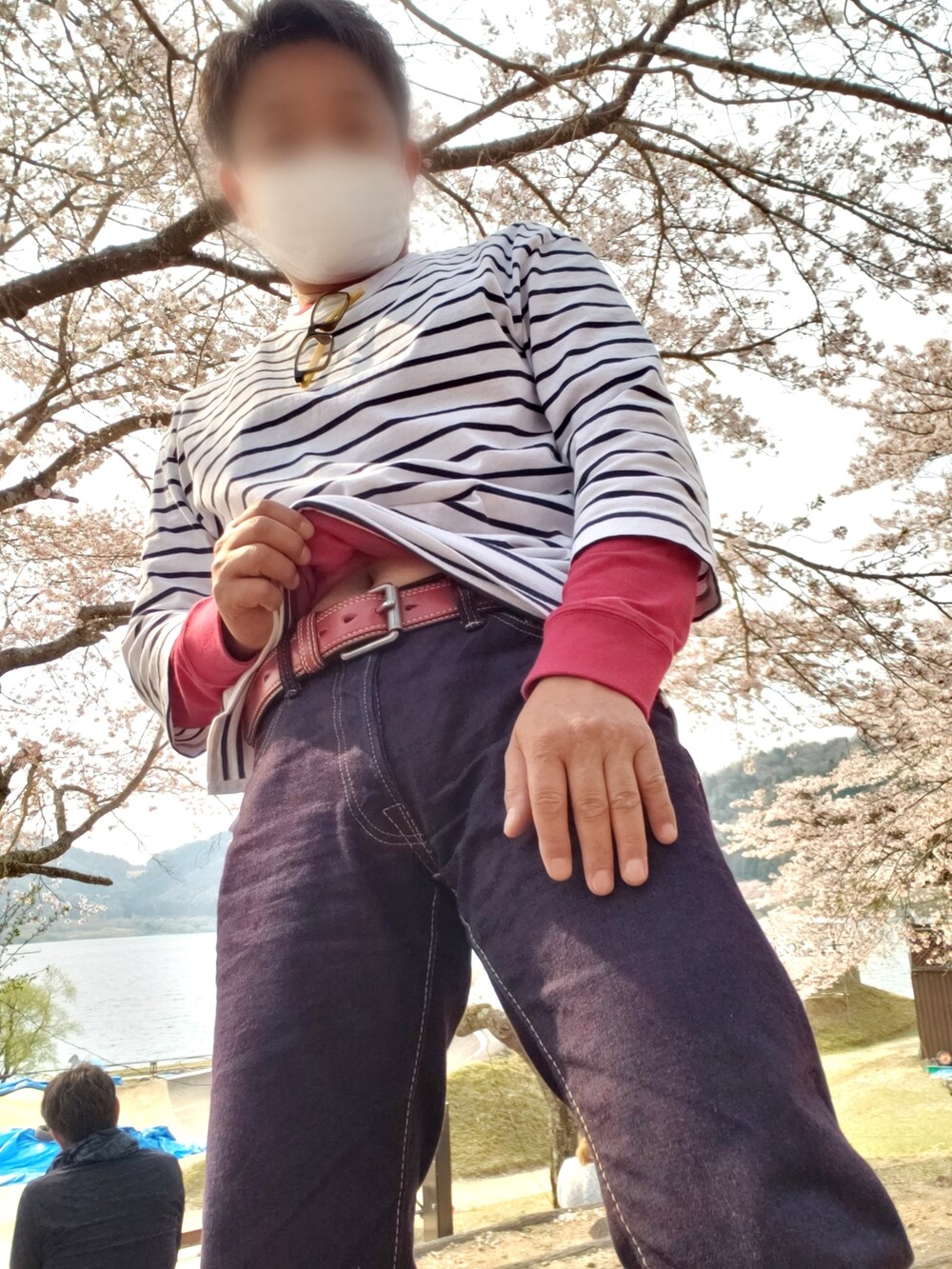 レッド系のデニムパンツ、グリーン系のブルゾン、ブラック系のショルダーバッグを着用したメンズの春コーディネートの2枚目の写真