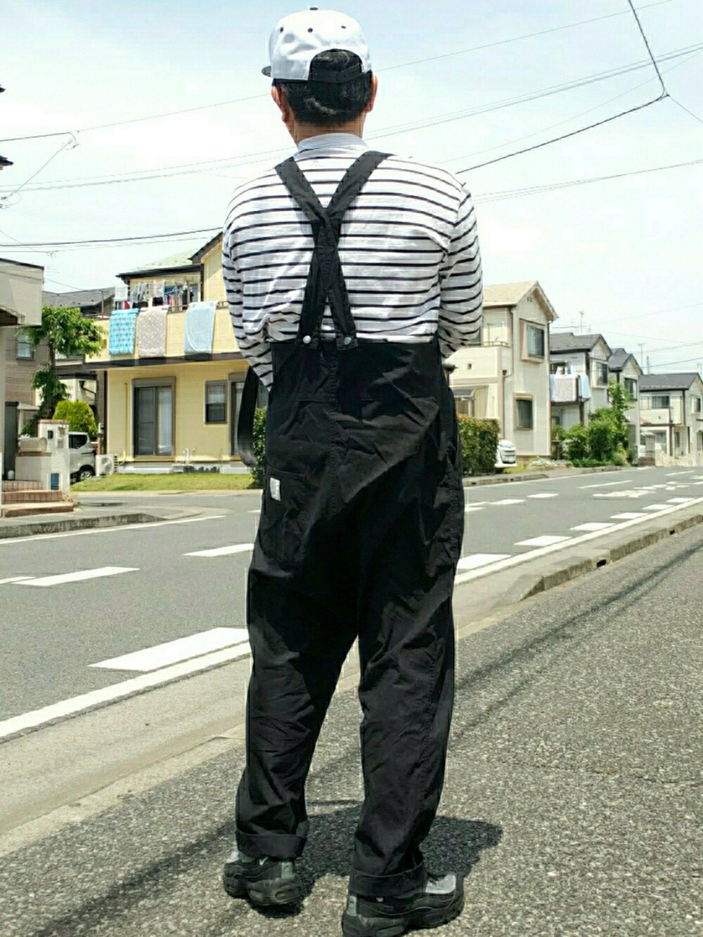 ブラック系のサロペット/オーバーオール、ブラック系のショルダーバッグ、ブラック系のスニーカーを着用したメンズの春コーディネートの2枚目の写真