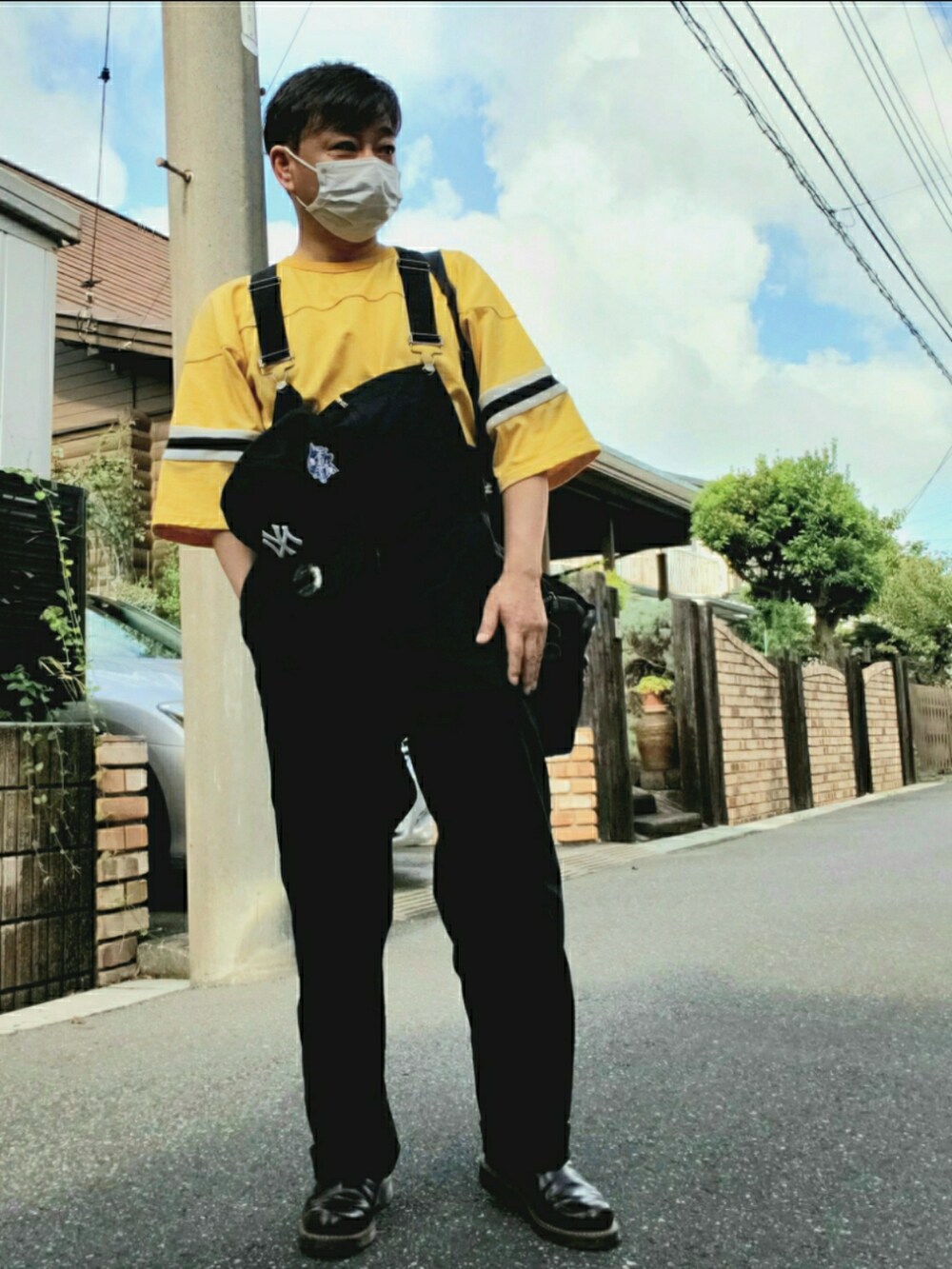 イエロー系のTシャツ/カットソー、ブラック系のショルダーバッグ、ブラウン系のブーツを着用したメンズの夏コーディネートの2枚目の写真