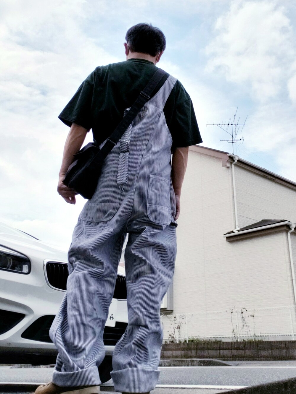 ブルー系のショルダーバッグ、その他のサロペット/オーバーオール、グリーン系のTシャツ/カットソーを着用したメンズの夏コーディネートの2枚目の写真