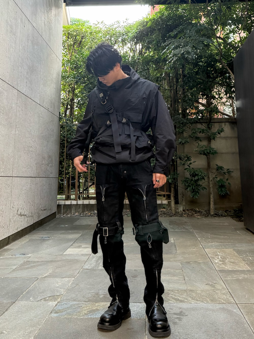 ブラック系のデニムパンツ、ブラック系のブーツ、ブラック系のベストを着用したメンズの秋コーディネートの2枚目の写真