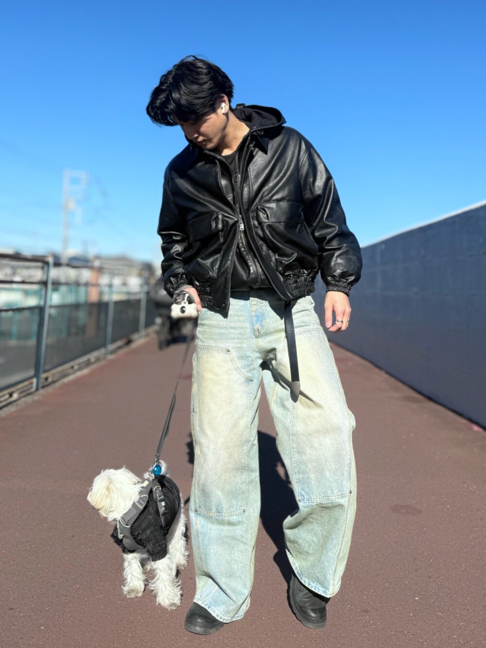 ブラック系のブルゾン、ブルー系のデニムパンツ、ブラック系のパーカーを着用したメンズの冬コーディネートの4枚目の写真