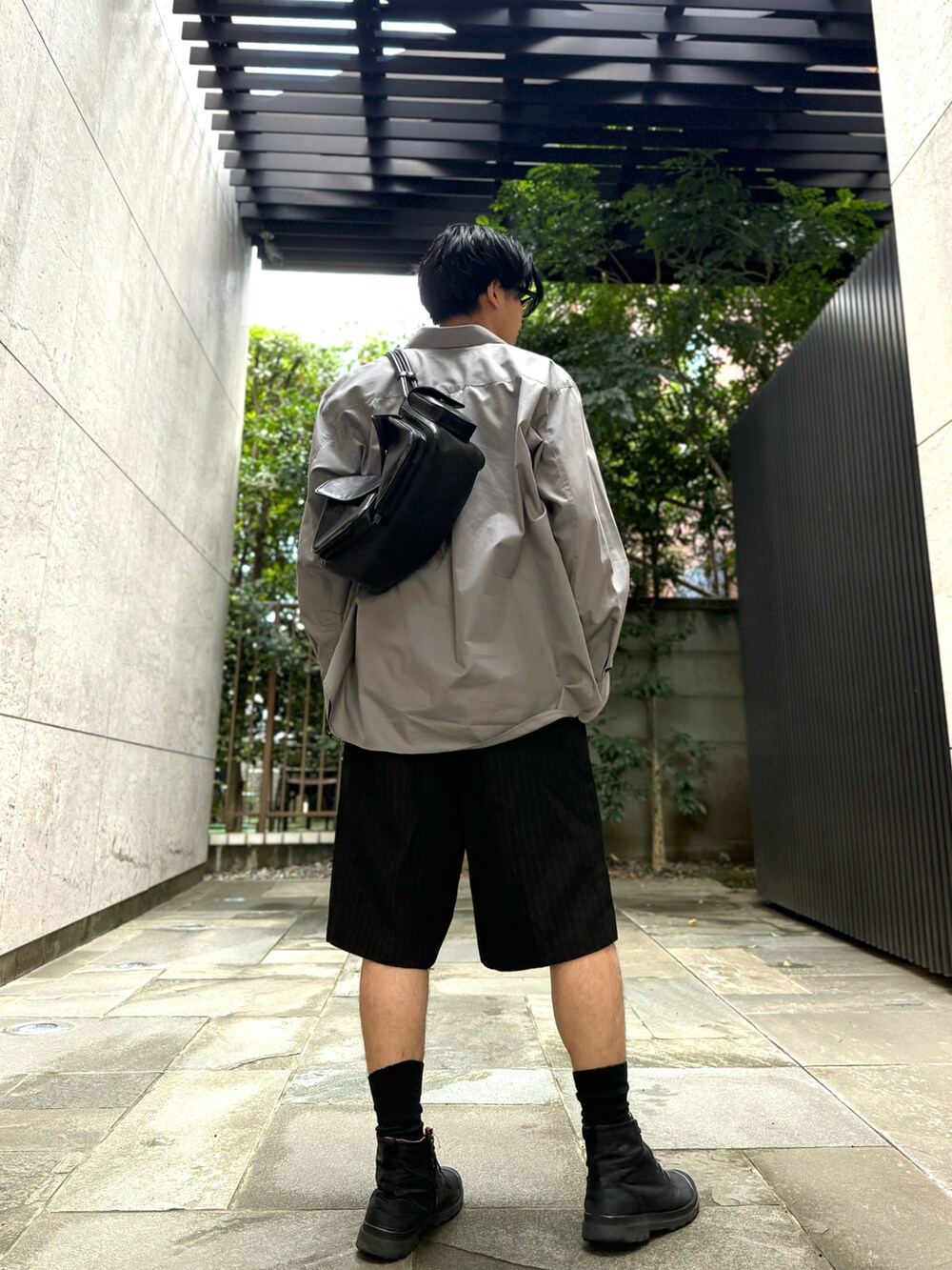 ブルー系のシャツ/ブラウス、ブラック系のその他パンツ、ブラック系のハンドバッグを着用したメンズの秋コーディネートの4枚目の写真