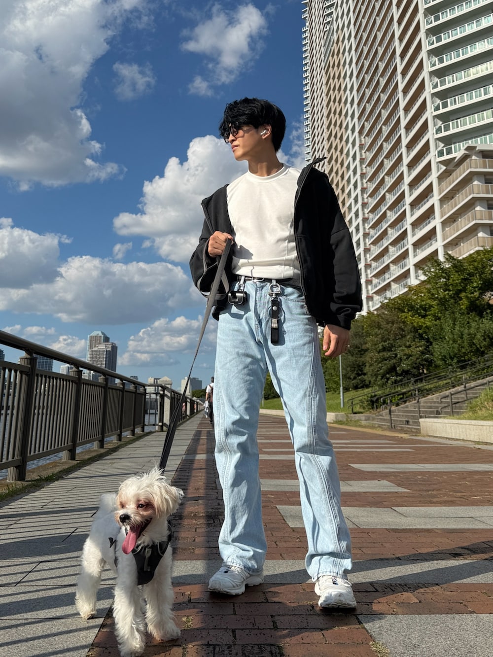 ブルー系のデニムパンツ、ホワイト系のスニーカー、グレー系のパーカーを着用したメンズの秋コーディネートの3枚目の写真