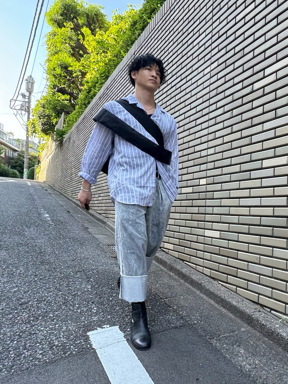 グレー系のデニムパンツ、ブラック系のブーツ、ブルー系のシャツ/ブラウスを着用したメンズの夏コーディネートの2枚目の写真