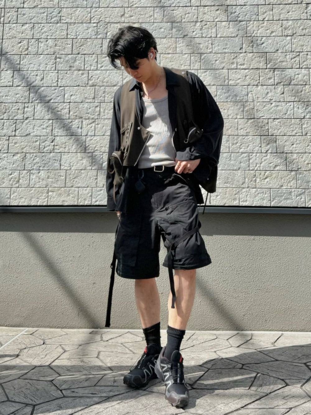 ブラック系のカーゴパンツ、その他のベスト、ブラウン系のスニーカーを着用したメンズの春コーディネートの2枚目の写真