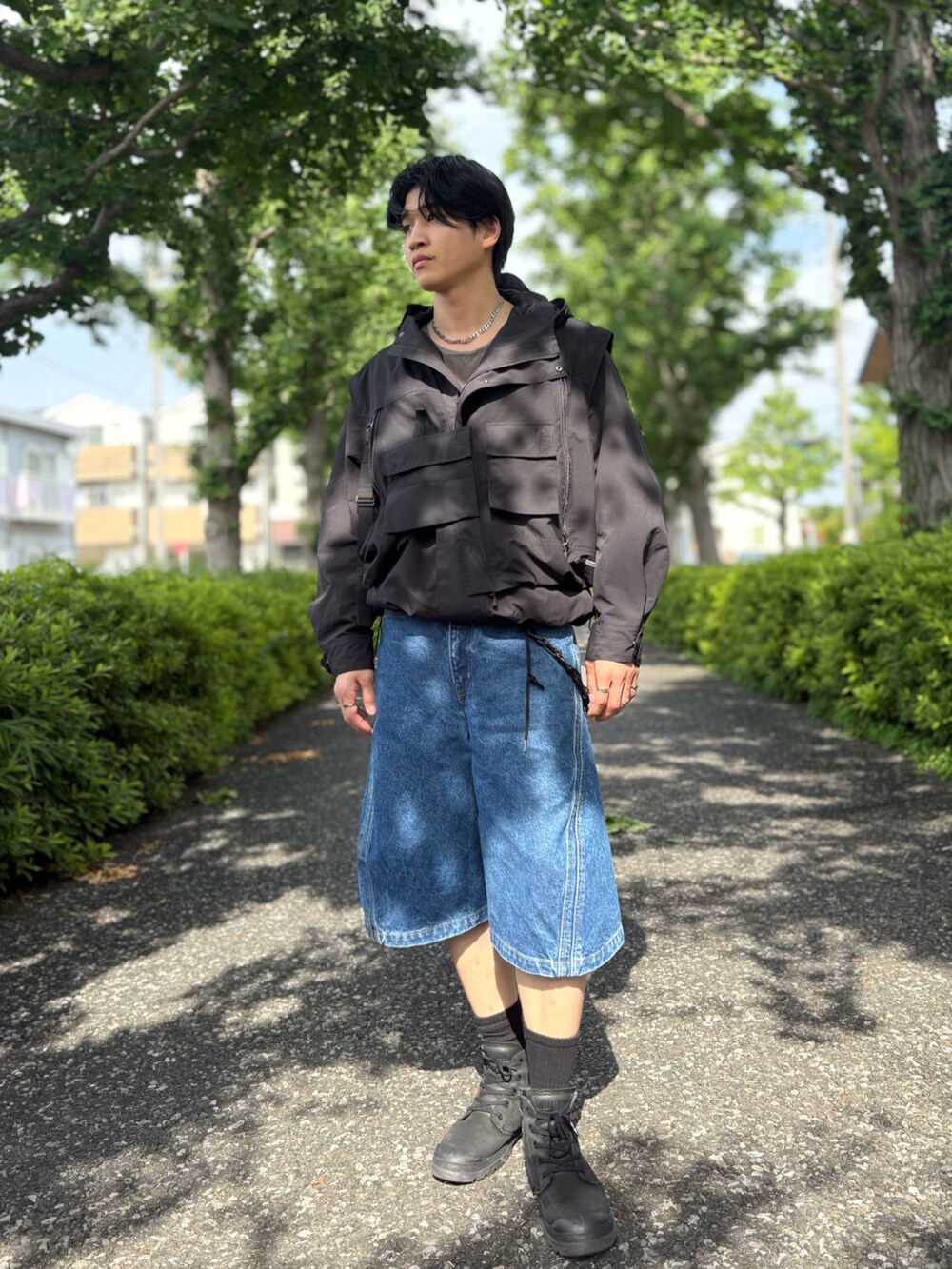 ブルー系のデニムパンツ、ブラック系のベスト、ブラック系のその他トップスを着用したメンズの夏コーディネートの2枚目の写真